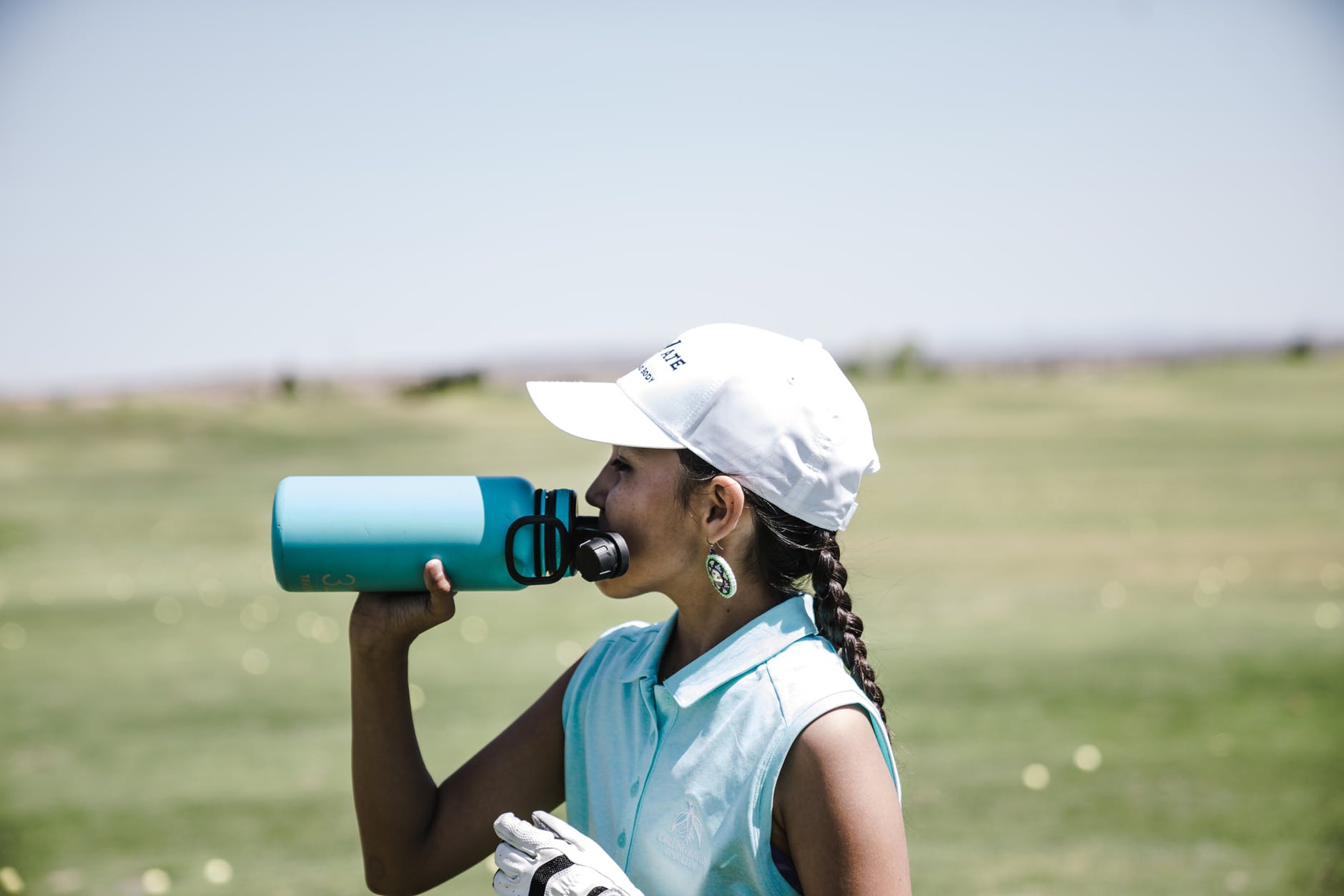 image of a golfer staying hydrated on the golf course